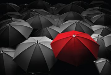 Red umbrella among black